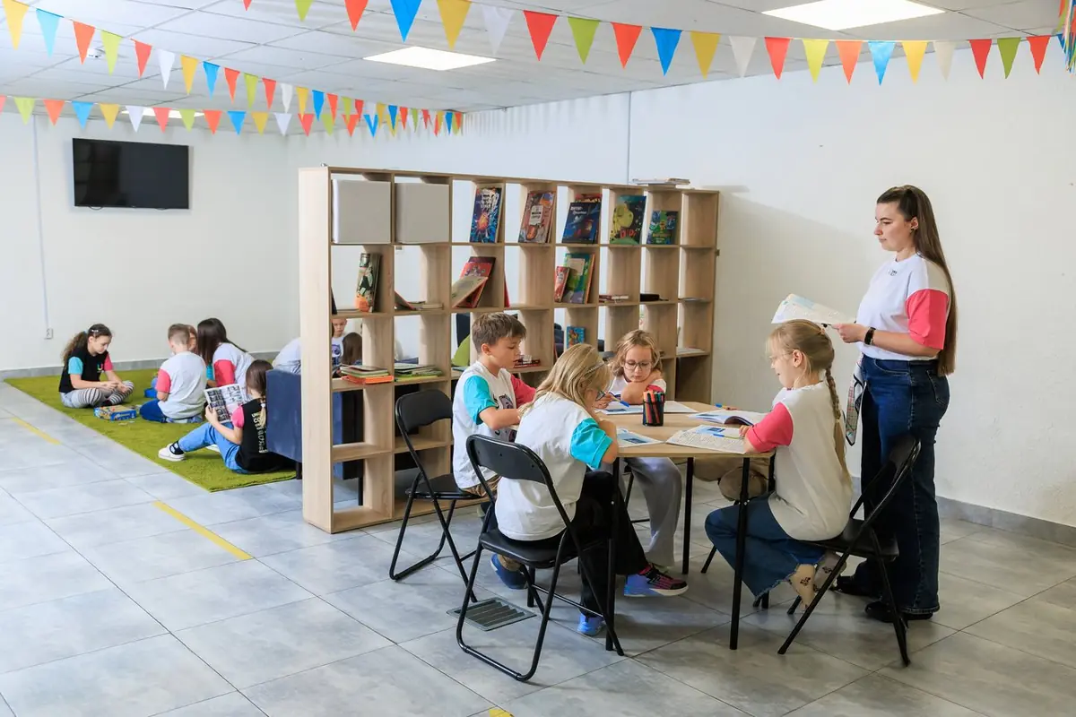 Простір укриття приватної школи Unique School: килим, стелажі, столи для уроків