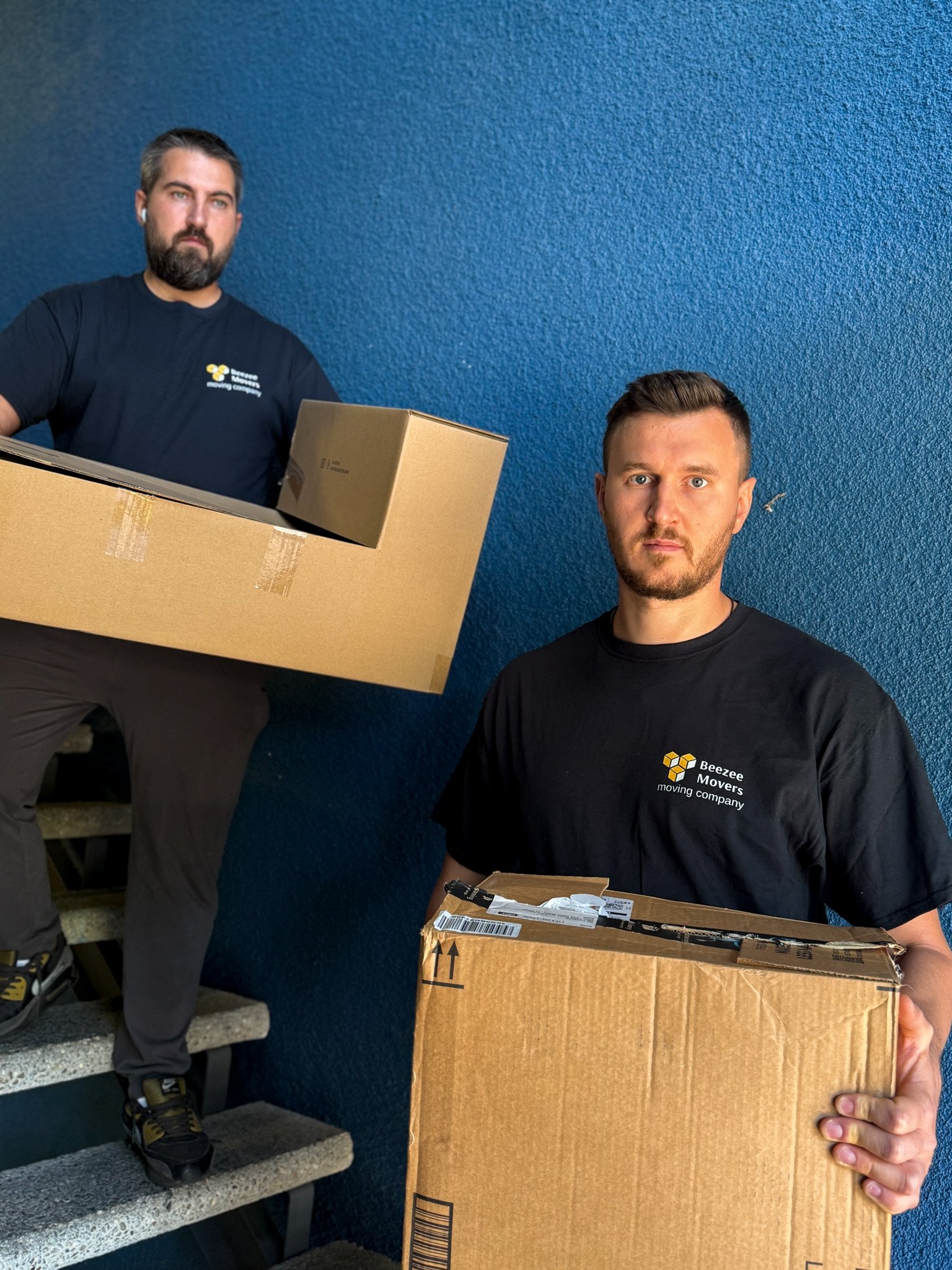 Professional movers carefully carrying wrapped furniture in Los Angeles residential area, demonstrating safe and efficient local moving services in 2026