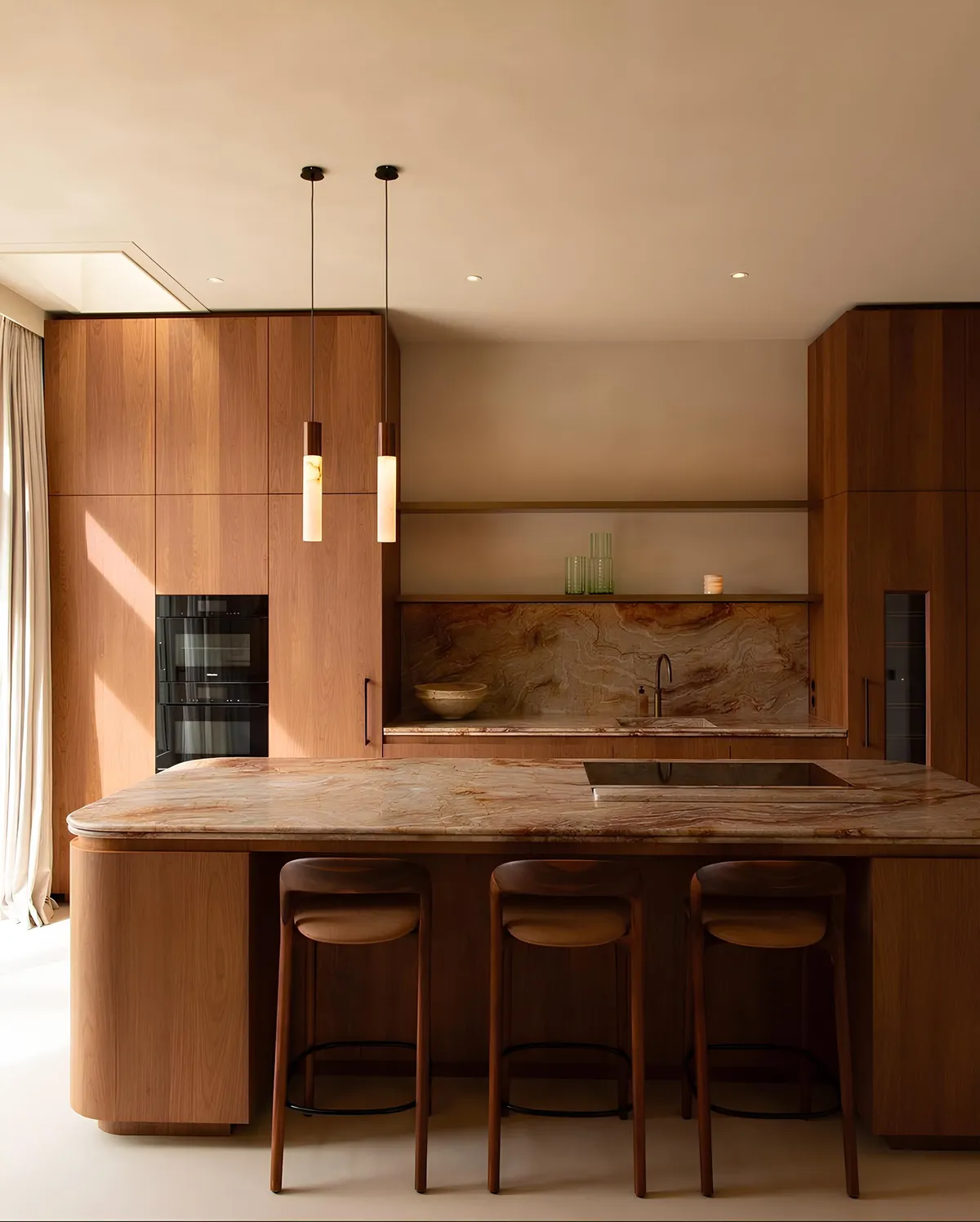 A Manhattan kitchen with walnut cabinetry, a stone-topped island and pendant lights