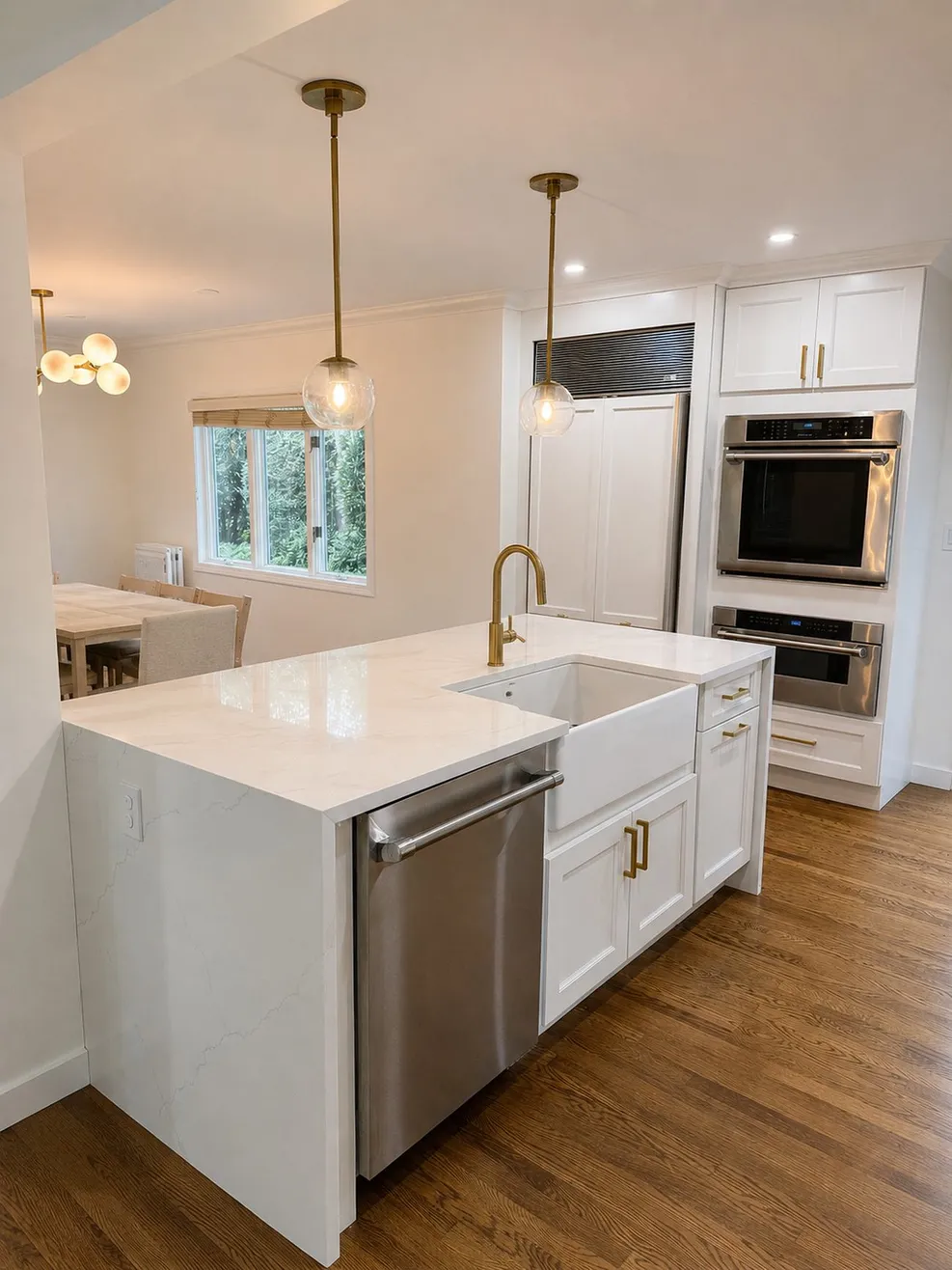 A white Queens kitchen with a quartz waterfall island and brass pendant lights