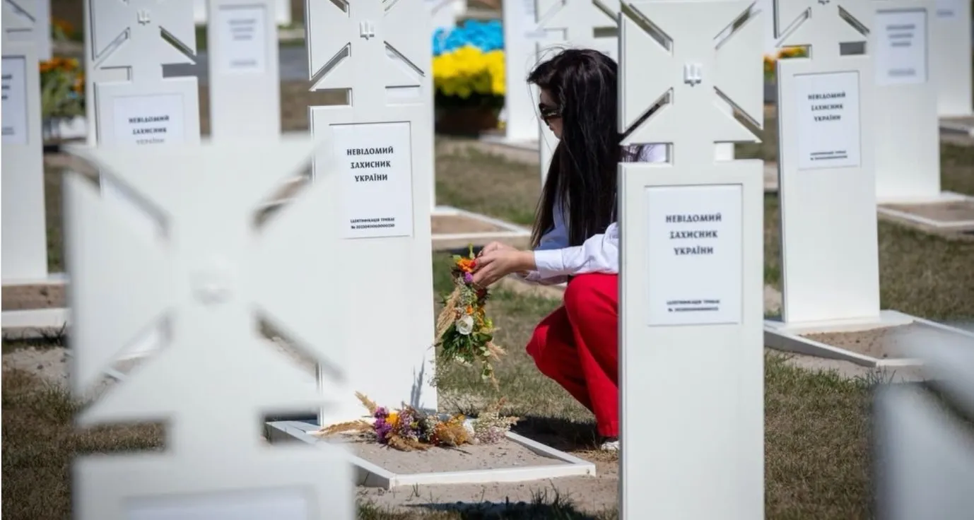 Учасниця акції покладає вінок біля поховання невідомого захисника України