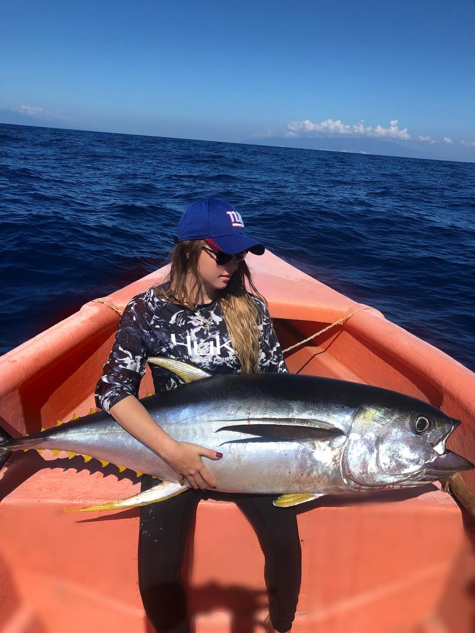 Une personne assise dans une embarcation avec un poisson