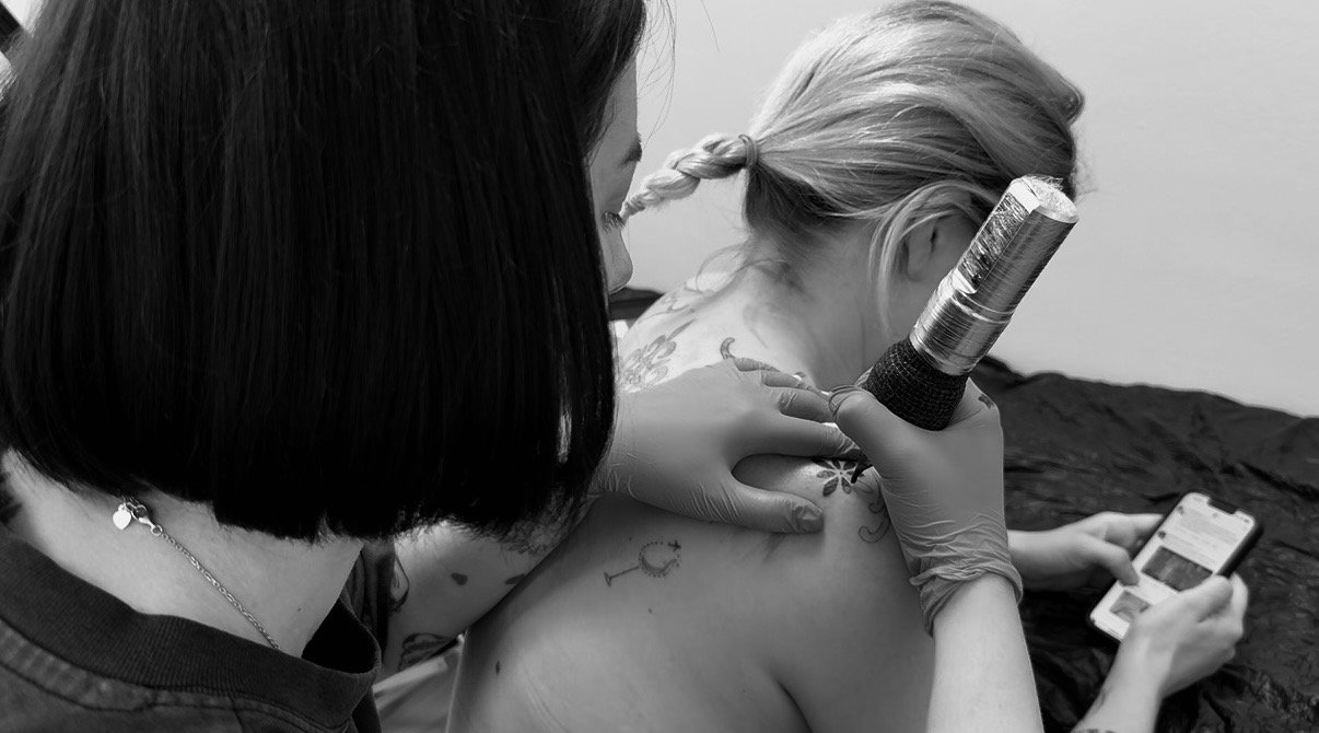 Tattoo artist creating a new design on a client's arm